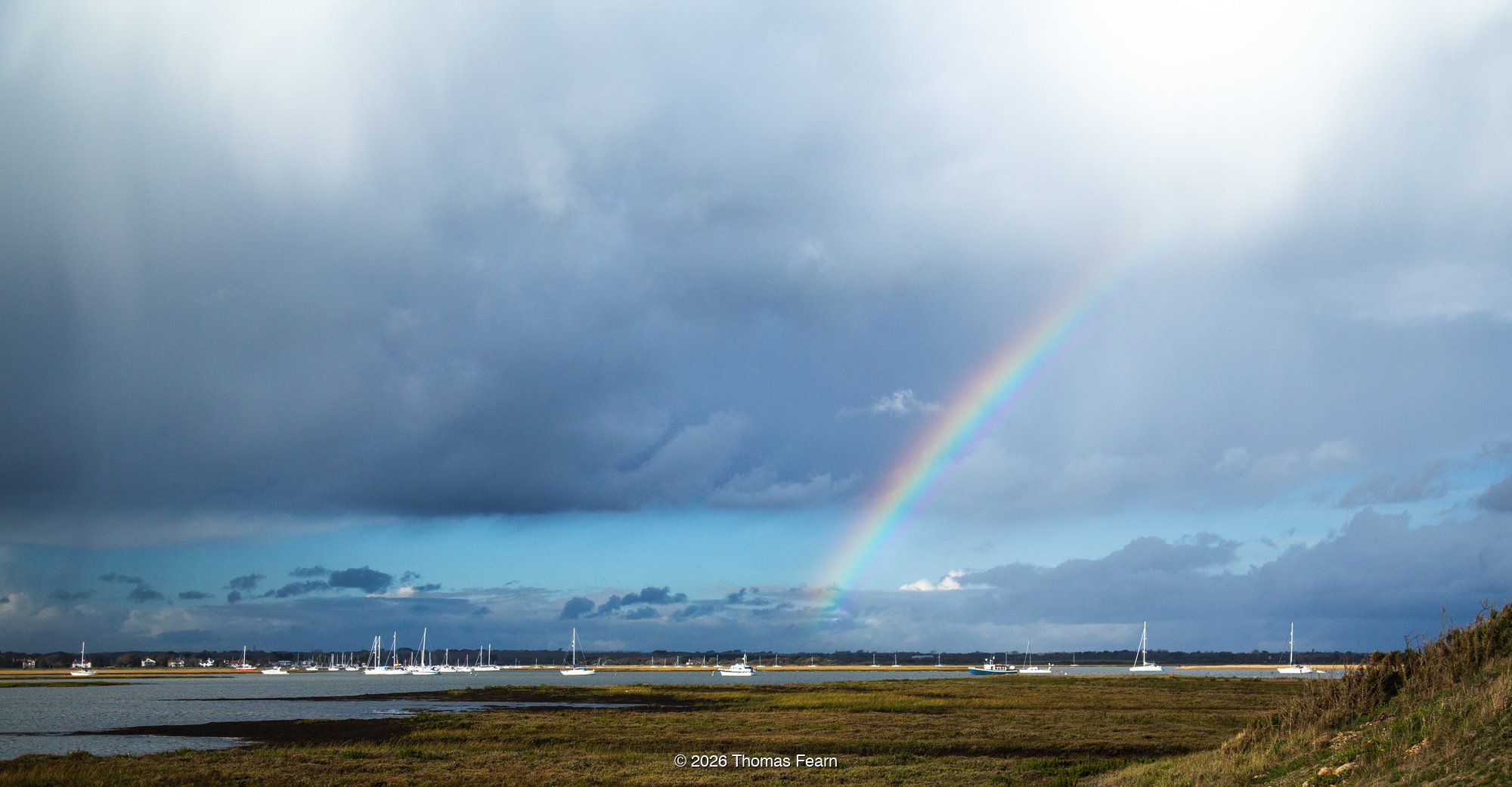 Storm light over distant coast and harbour